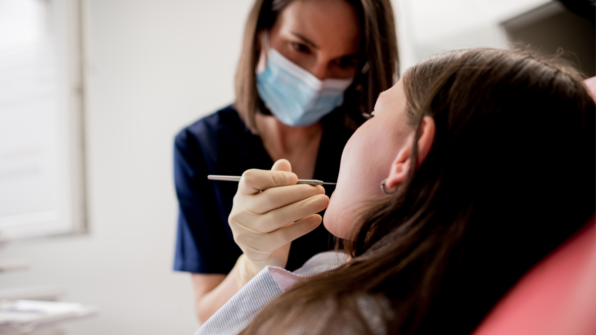 Dr. Schiessl trägt eine Maske und behandelt Patientin, welche zu ihr sieht