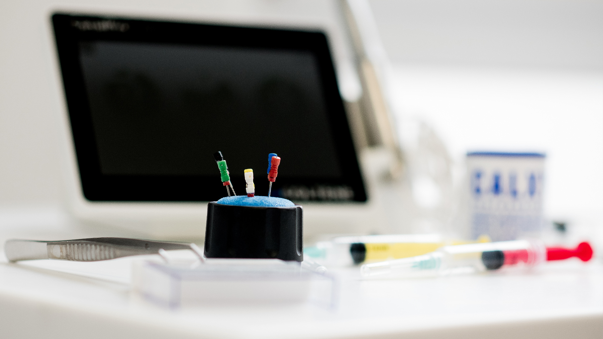 Wurzelkanalbehandlung Werkzeug auf einem Tisch mit Display im Hintergrund